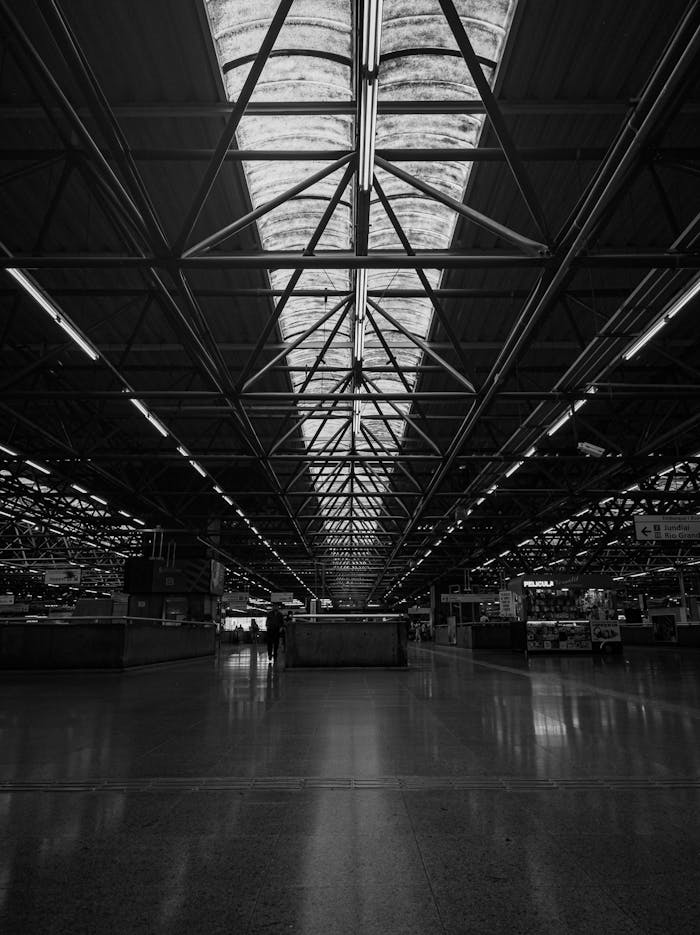Black and white interior view of a spacious modern warehouse with industrial lighting.
